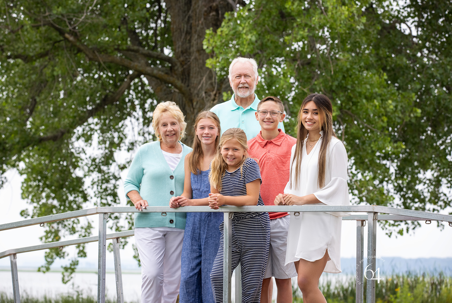 Grandparents with grandchildren standing on a bridge in front of Leech Lake